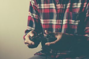 young man holding game controller playing video games